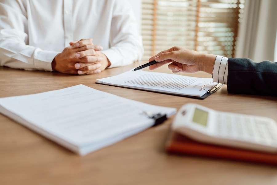 Un professionnel présente un contrat de mutuelle d'entreprise à un client lors d'un entretien formel.